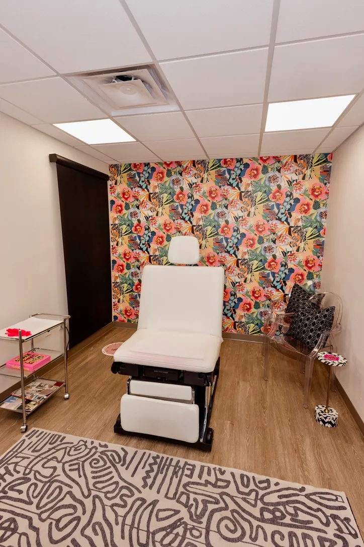 A treatment room with floral wallpaper