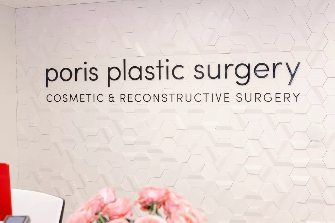 The Poris Plastic Surgery wordmark on the reception hexagon wall